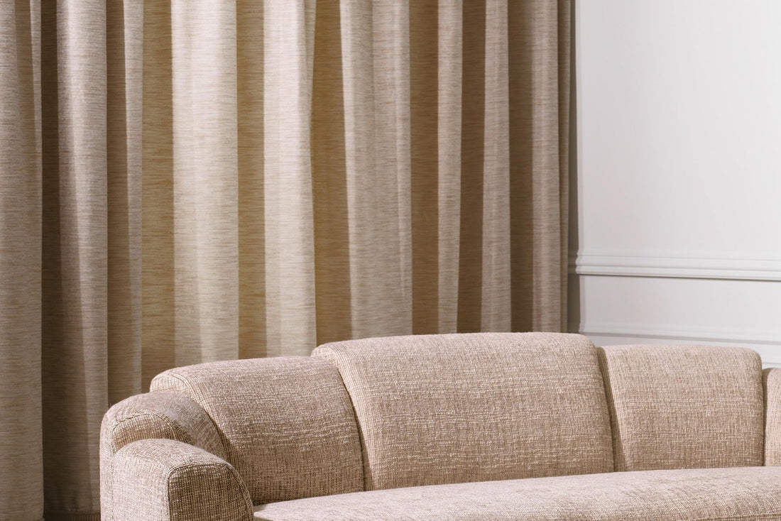 Beiges Sofa vor hellem Vorhang