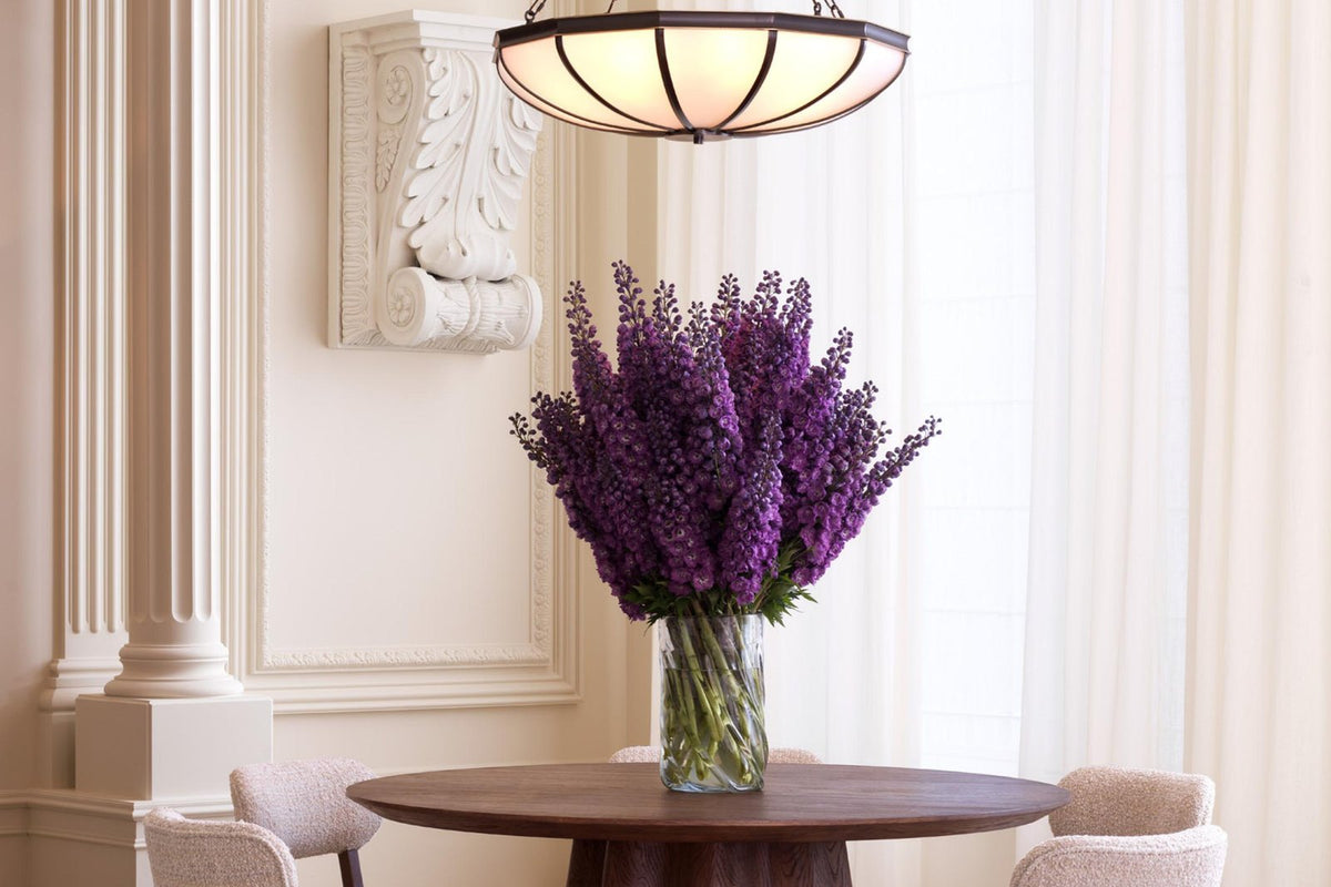 Elegantes Esszimmer mit Holztisch und lila Blumen
