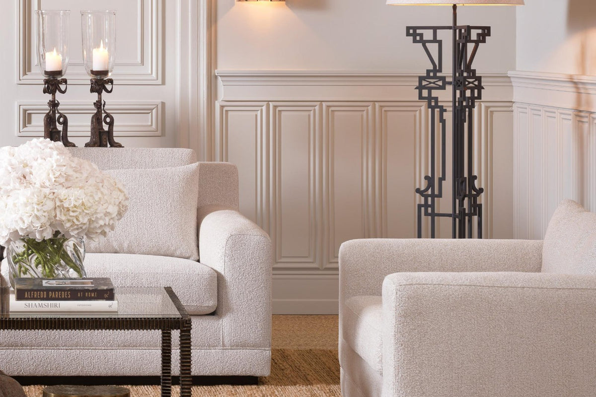Elegantes Wohnzimmer mit hellen Sesseln und stilvoller Beleuchtung