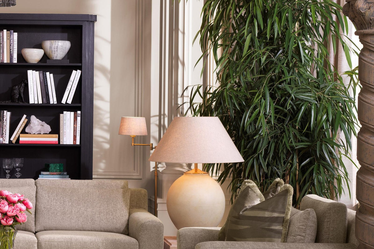 Elegantes Wohnzimmer mit Sofa, Sessel und großer Pflanze