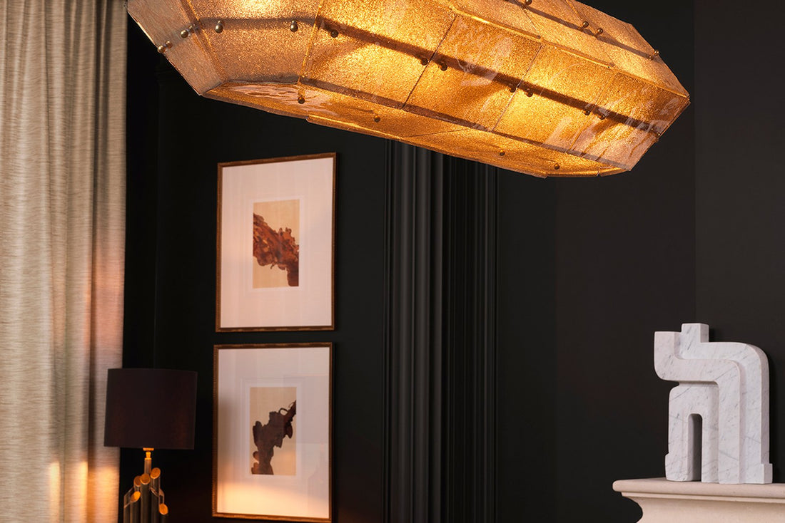 Luxuriöses Wohnzimmer mit goldener Pendelleuchte und Barwagen